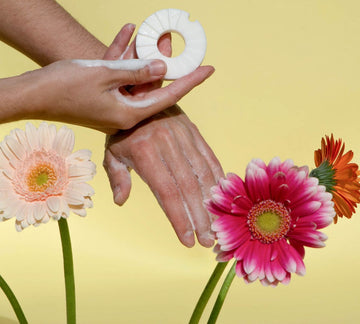 Hydraterend schuimende handen met Lesseau blokzeep omringt door kleurrijke bloemen